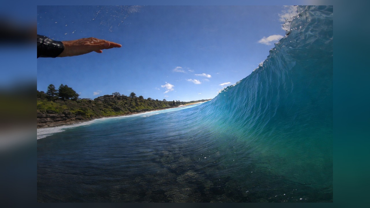 POV surfing through a barrel over a shallow reef