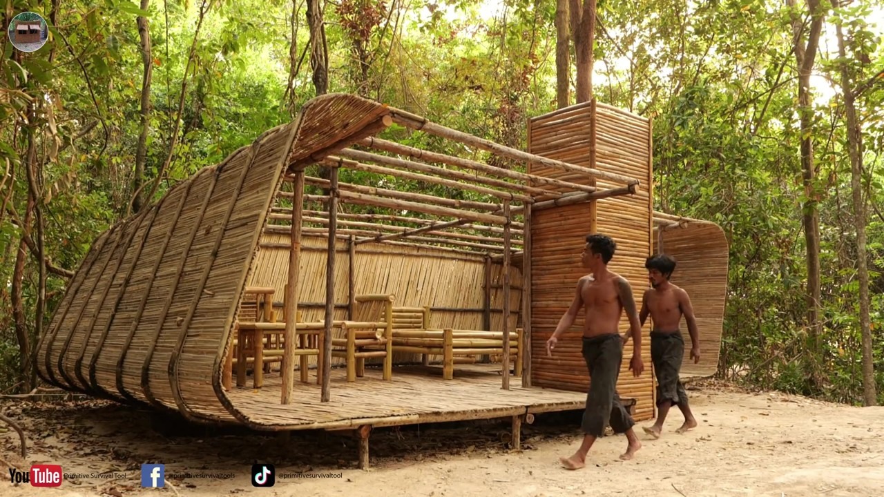 Builders finish a curved-wall bamboo cabin