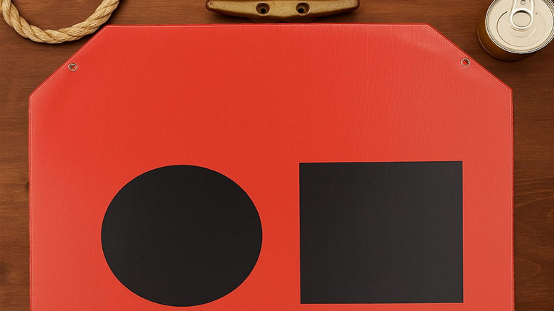 What does an orange flag with a black square and circle mean in boating?
