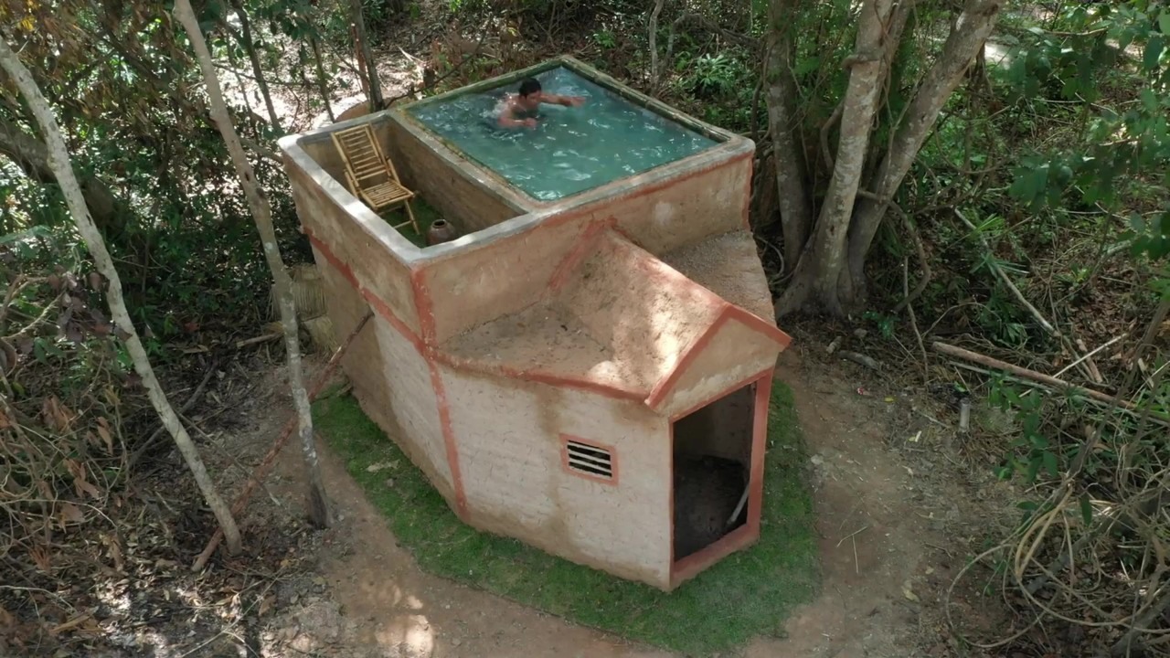 Turquoise swimming pool tops a mud house