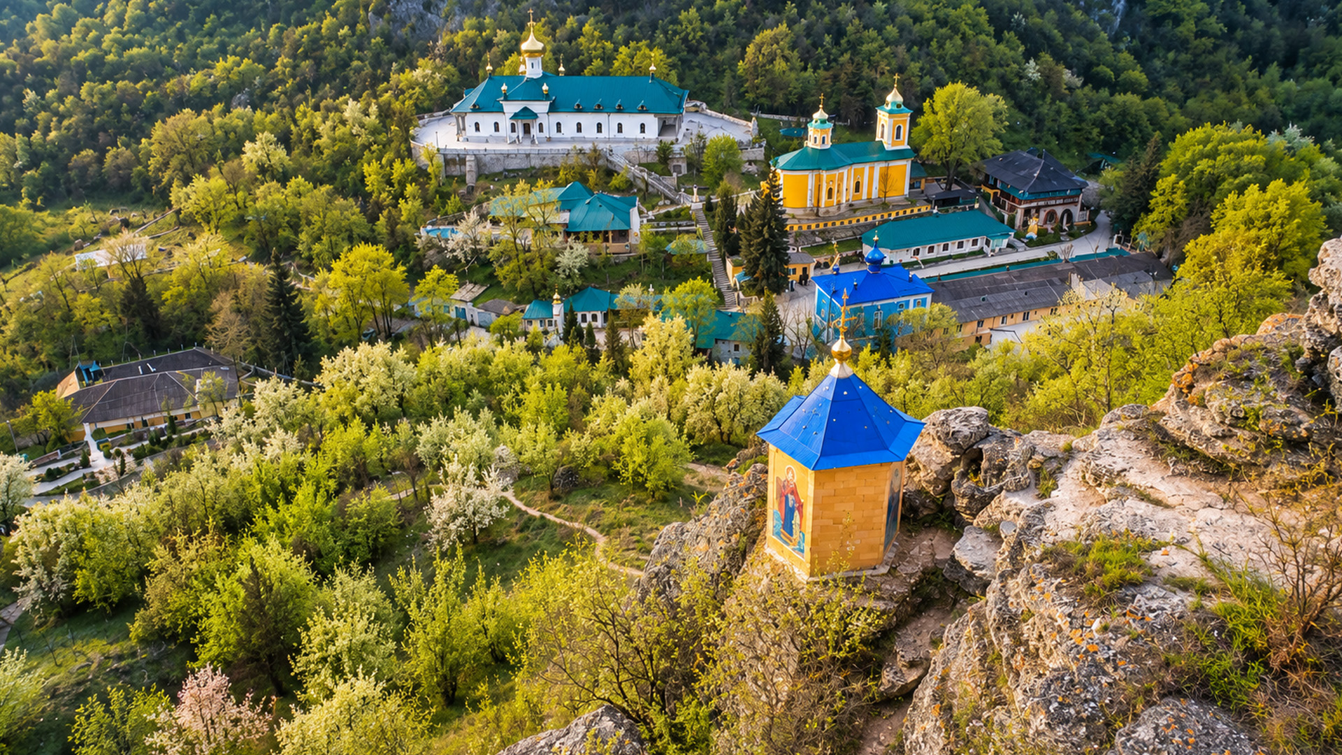 A hidden monastery surrounded by forest and rocky cliffs