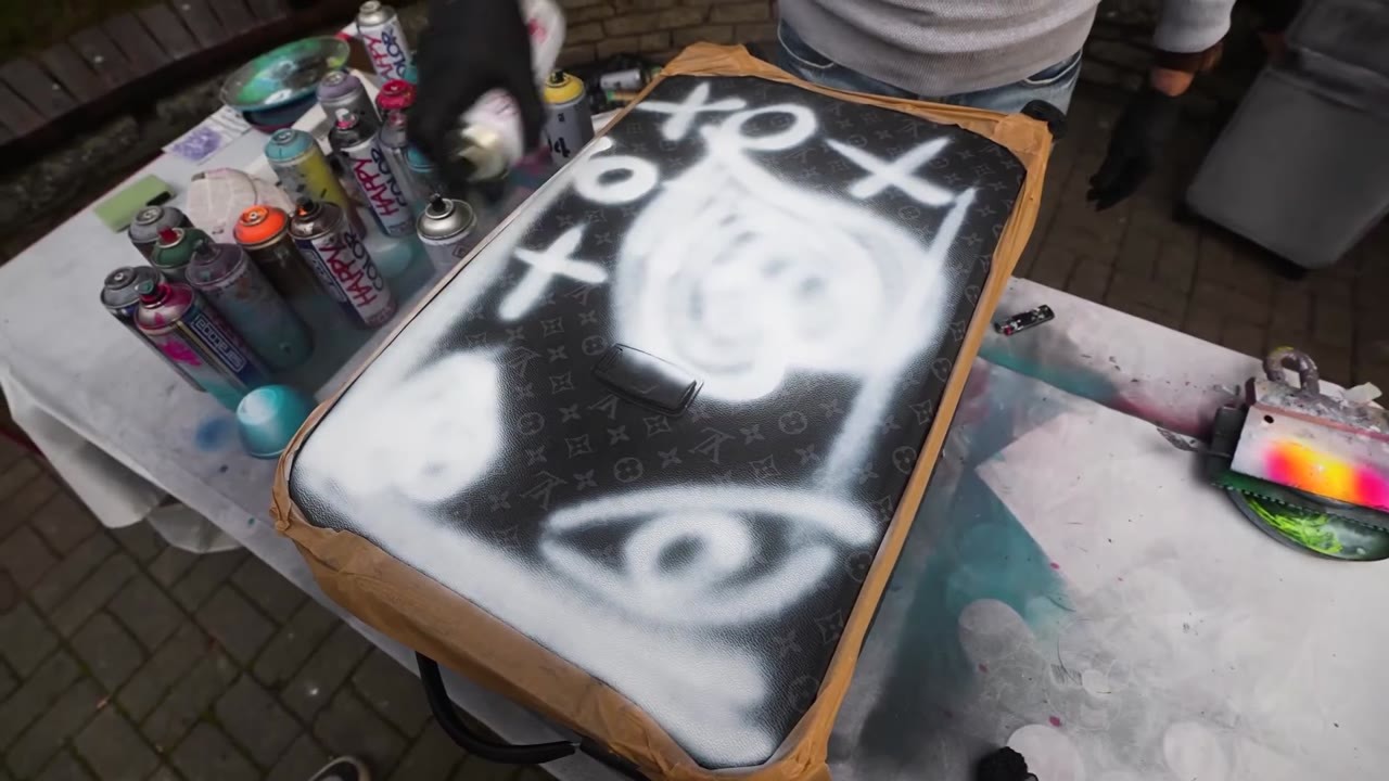 Spray painting a $2,000 Louis Vuitton suitcase