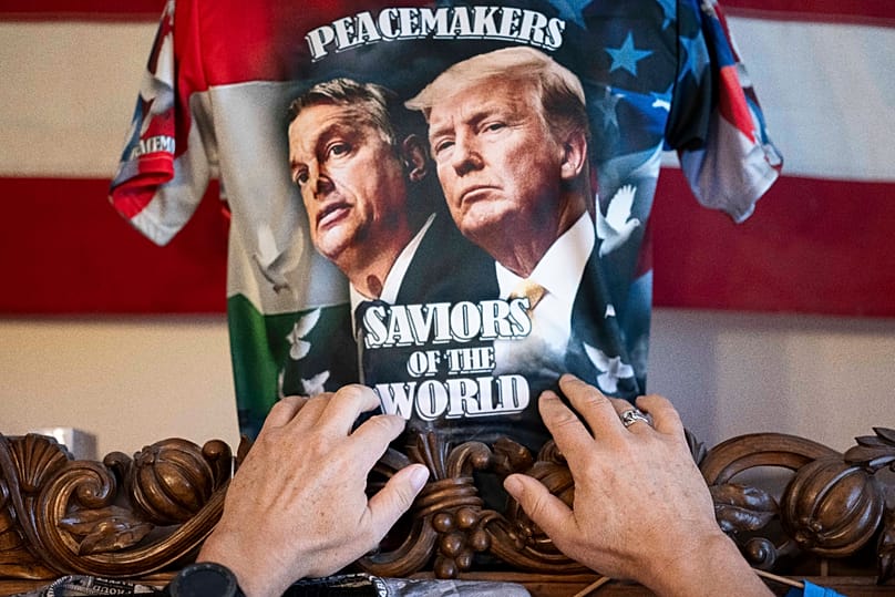 Ákos Szilágyi, uno dei più grandi fan di Viktor Orbán, il 14 aprile 2026 nella sua casa di Budapest sistema la maglietta da lui disegnata, su cui compaiono Orbán e Donald AP Photo/Denes Erdos