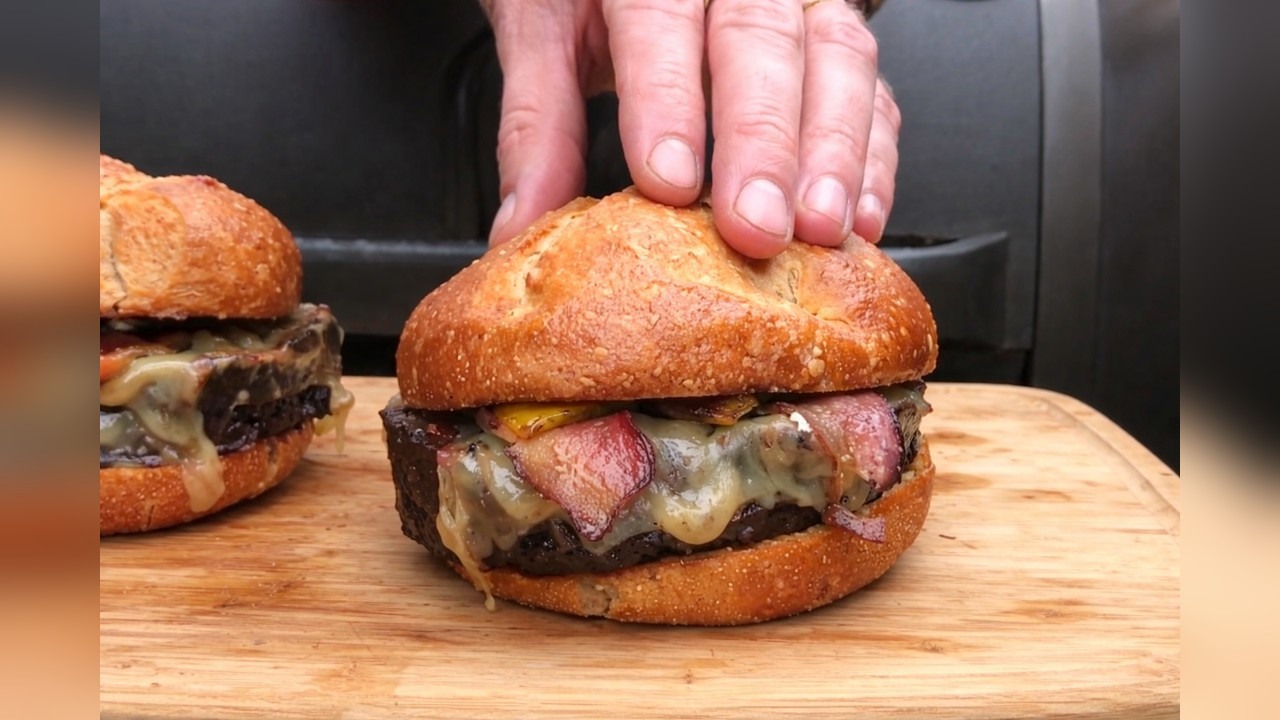Smoked whiskey cheeseburgers cook low and slow at the pit