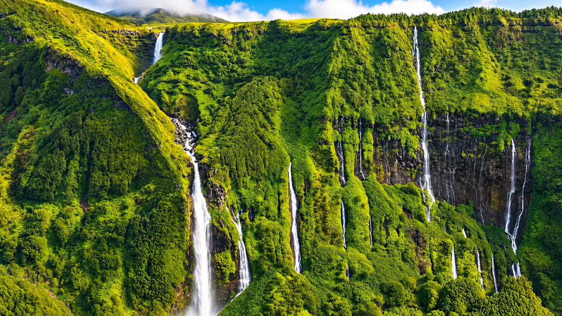 Countless waterfalls cascading down towering cliffs covered in lush ...
