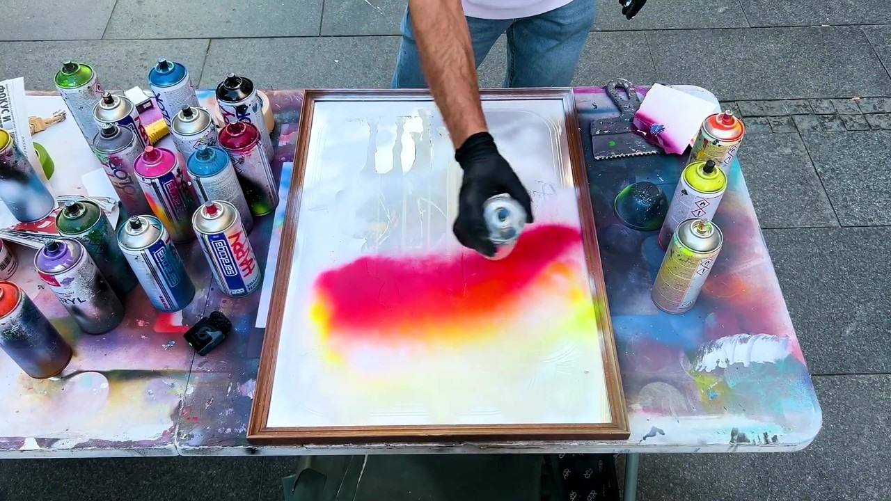 A stranger spray paints a mirror around a policeman