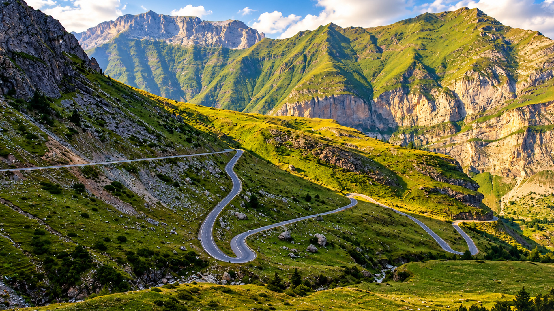 A zigzag road cutting through the green mountains