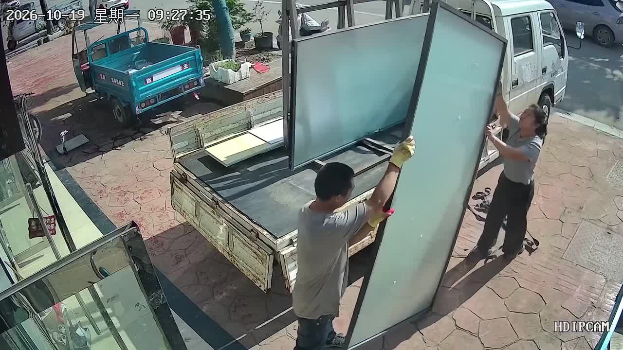 Glass panel topples from truck and shatters as workers unload glass