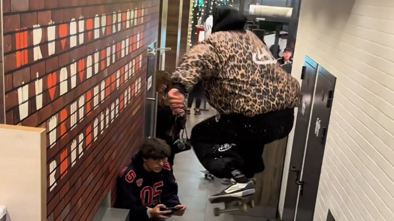 Boys perform scooter jump down restaurant steps