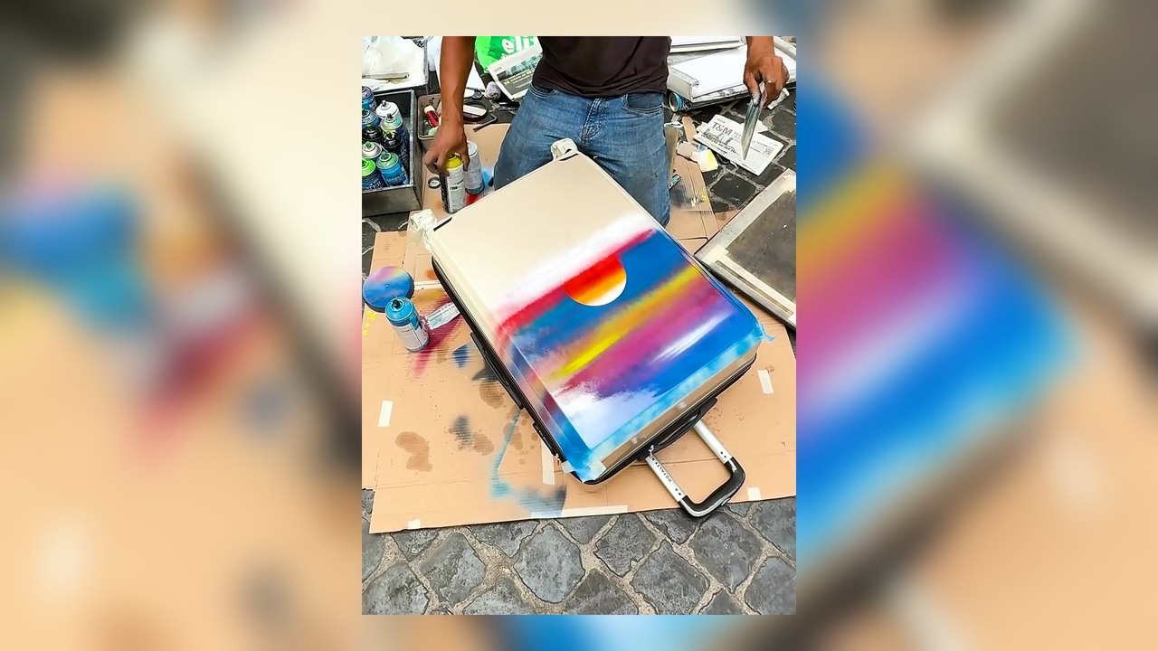 Street artist spray paints my suitcase in Rome