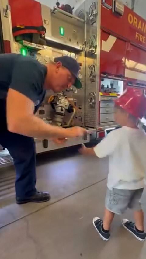 Young child thanks firefighters with doughnuts