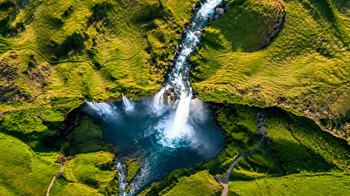 A beautiful waterfall surrounded by vibrant green hills and mossy cliffs