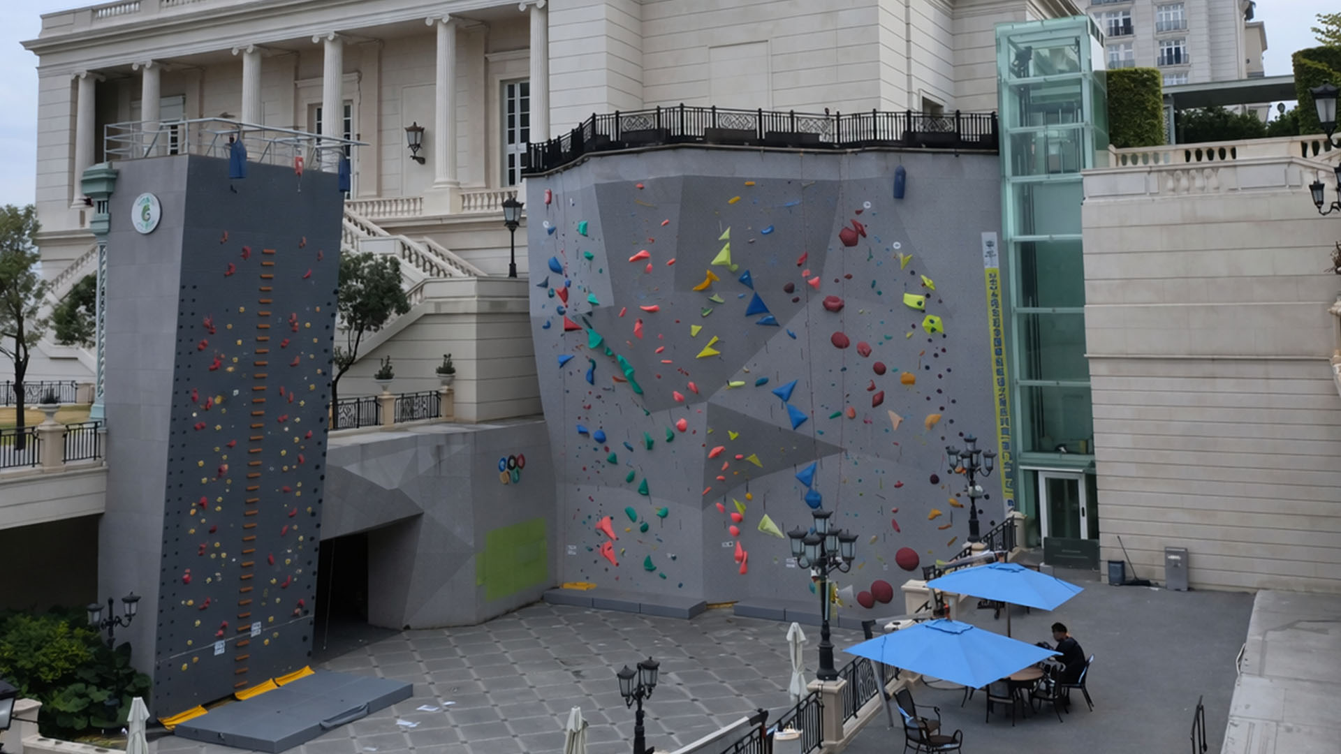 Giant climbing walls stand outside a European style palace in China