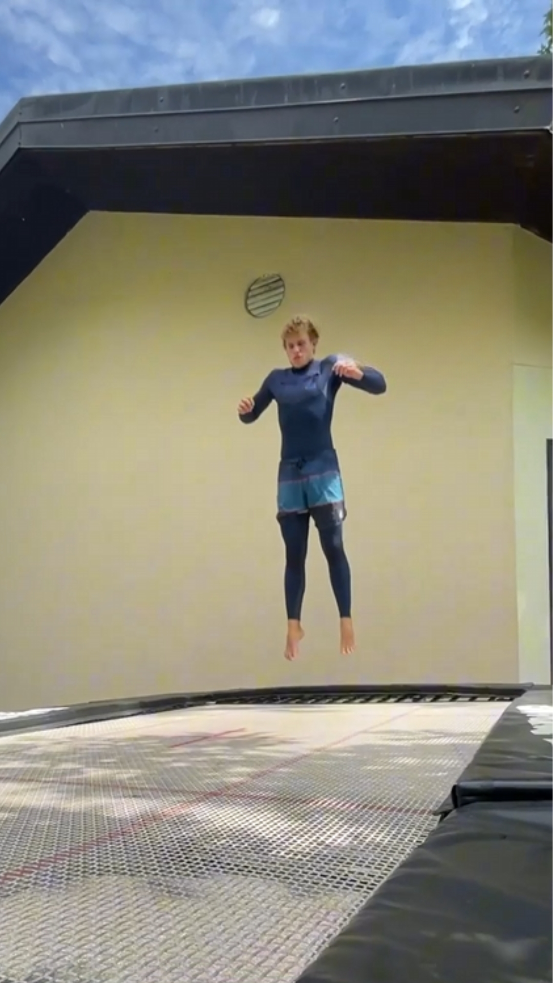 Adventurer attempts a risky trampoline trick near a cliff