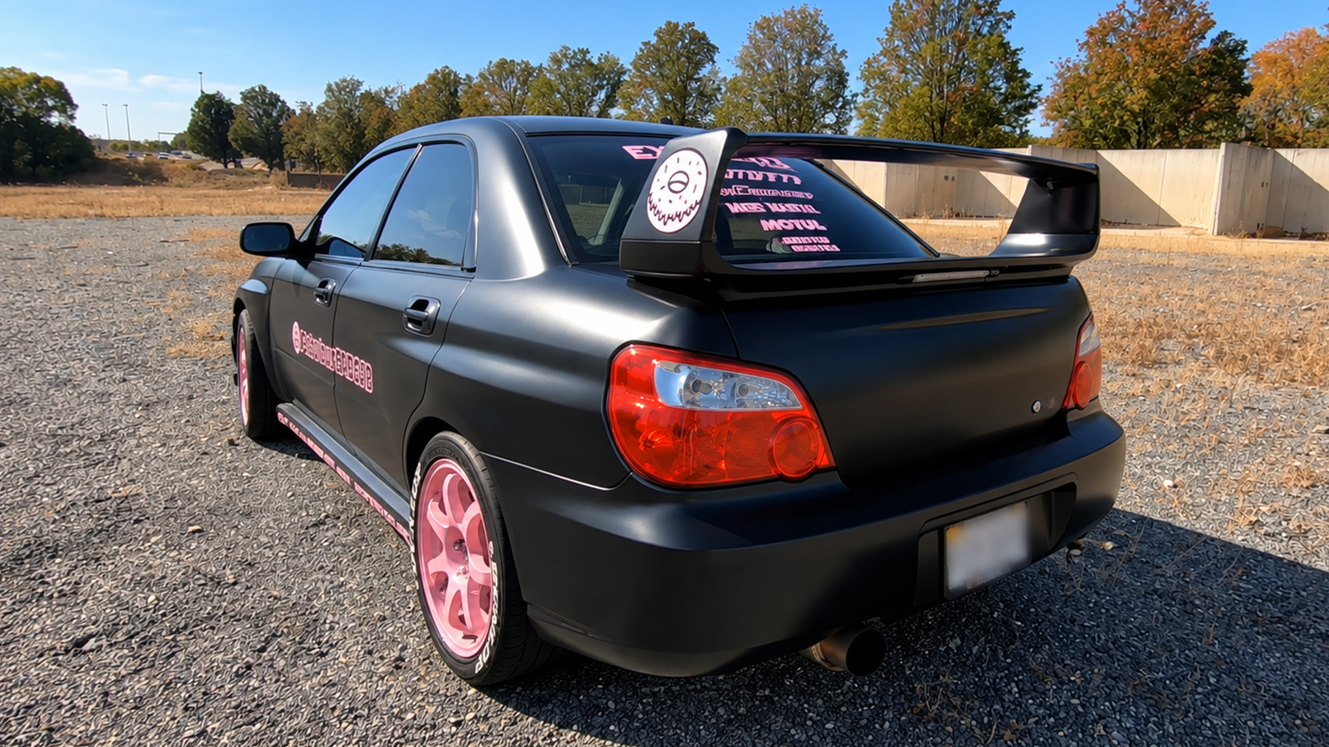 This car has pink wheels on one side and black on the other