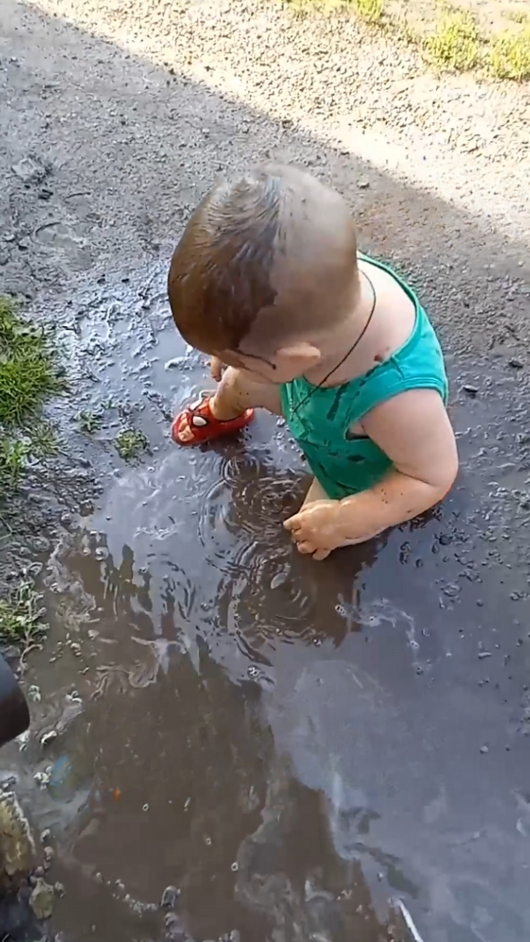 Toddler unexpectedly dips head into a puddle during playtime