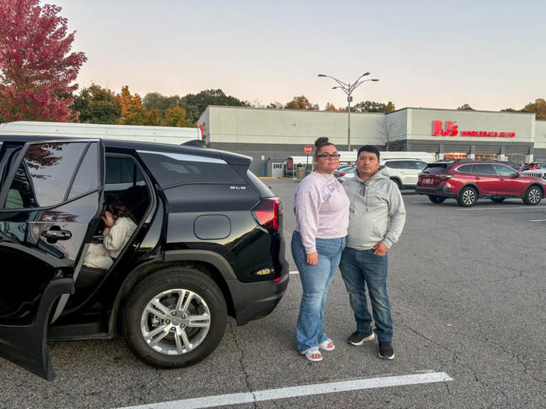 Joanice Patino, 49, and her husband Jose Patino, 47, stand next to their car in the parking lot of a BJ's Wholesale Club in Yorktown Heights, New York, a politically divided area in the US, October 18, 2026. Picture taken with a mobile phone. REUTERS/Danielle Kaye