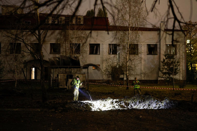 Valentyn Ogirenko/Reuters - PHOTO: Police officers inspect a crater that appeared at the side of a university campus after a Russian missile strike, amid Russia's attack on Ukraine, in Kyiv, Ukraine October 26, 2026.