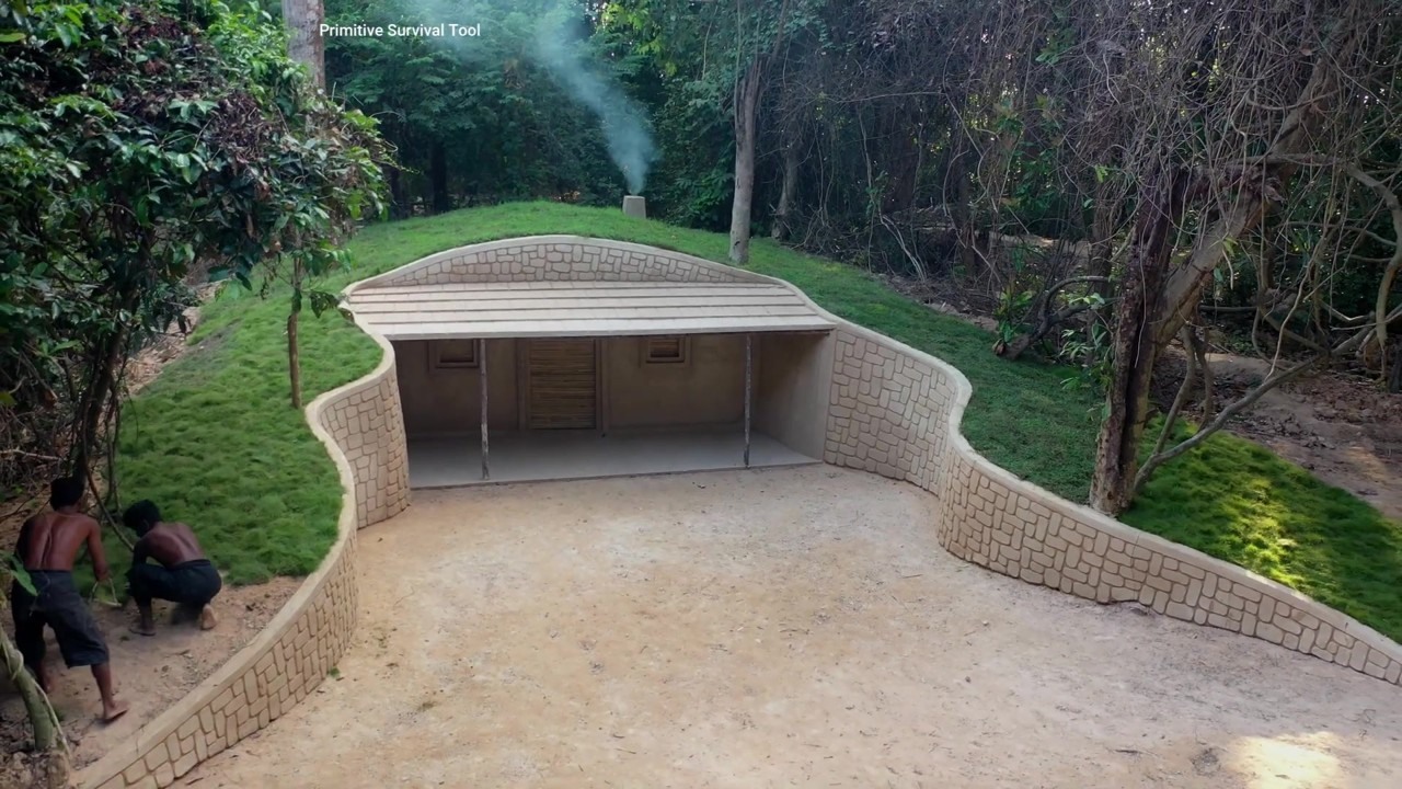 Grass-roofed hobbit house with curved stone-pattern walls