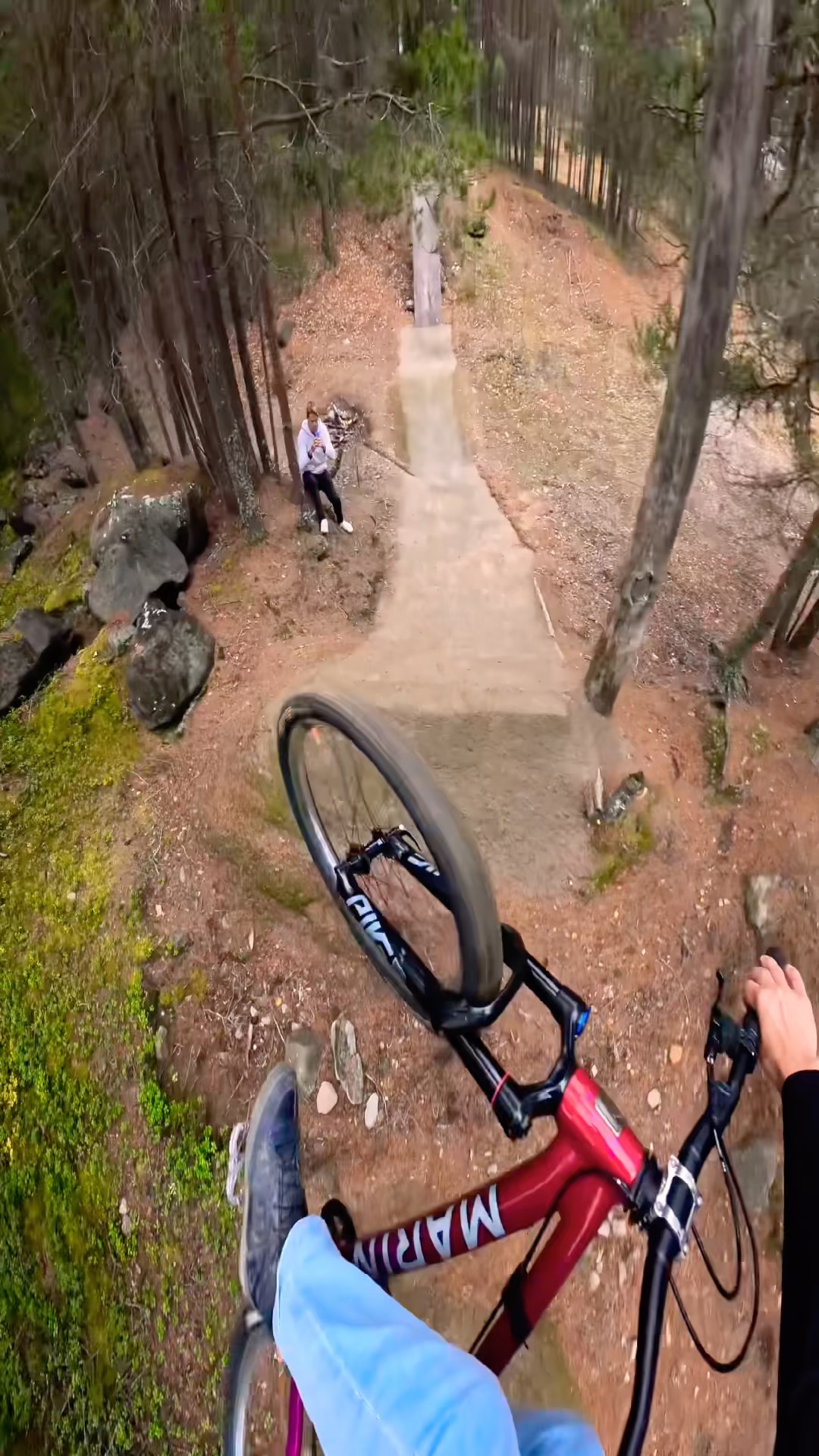 Riding huge dirt jumps through a dense forest trail