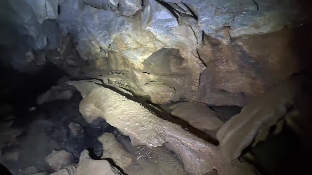 A cave explorer squeezes through a narrow exit and fears he has reached ...