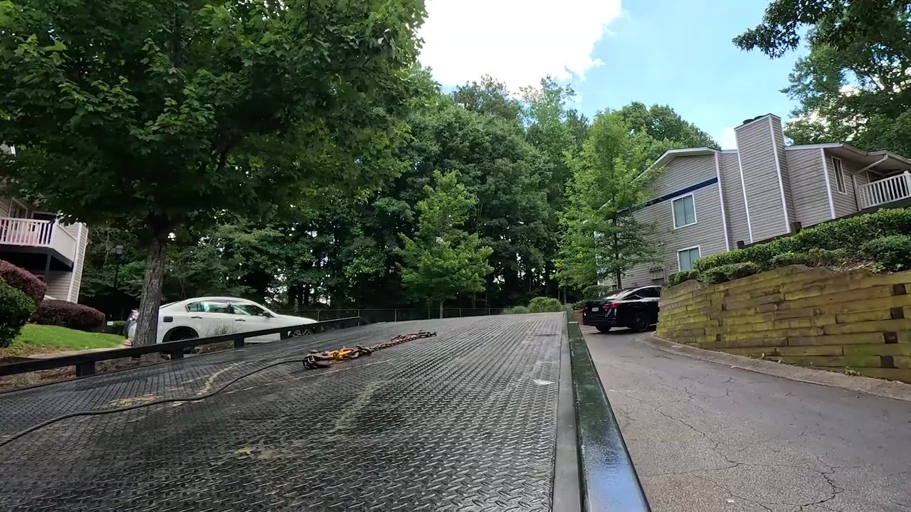 A tow truck operator hooks a car and spots an invalid tag