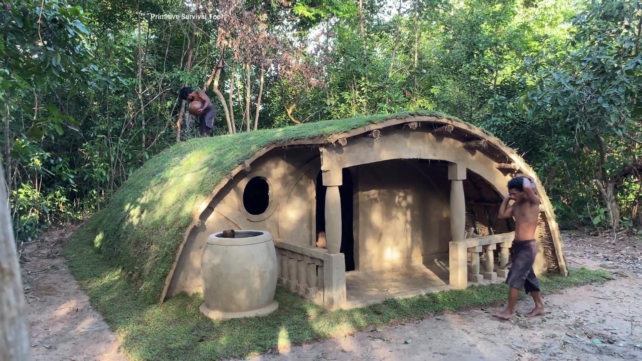 Finished underground jungle house with a curved grass roof