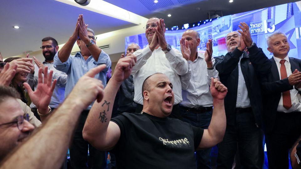 Supporters of Israel's Arab-led Joint List political alliance cheer at the alliance's campaign headquarters in the northern Israeli city of Nazareth on October 27, as the first exit polls are announced on television during Israel's legislative election. - Ahmad Gharabli/AFP via Getty Images