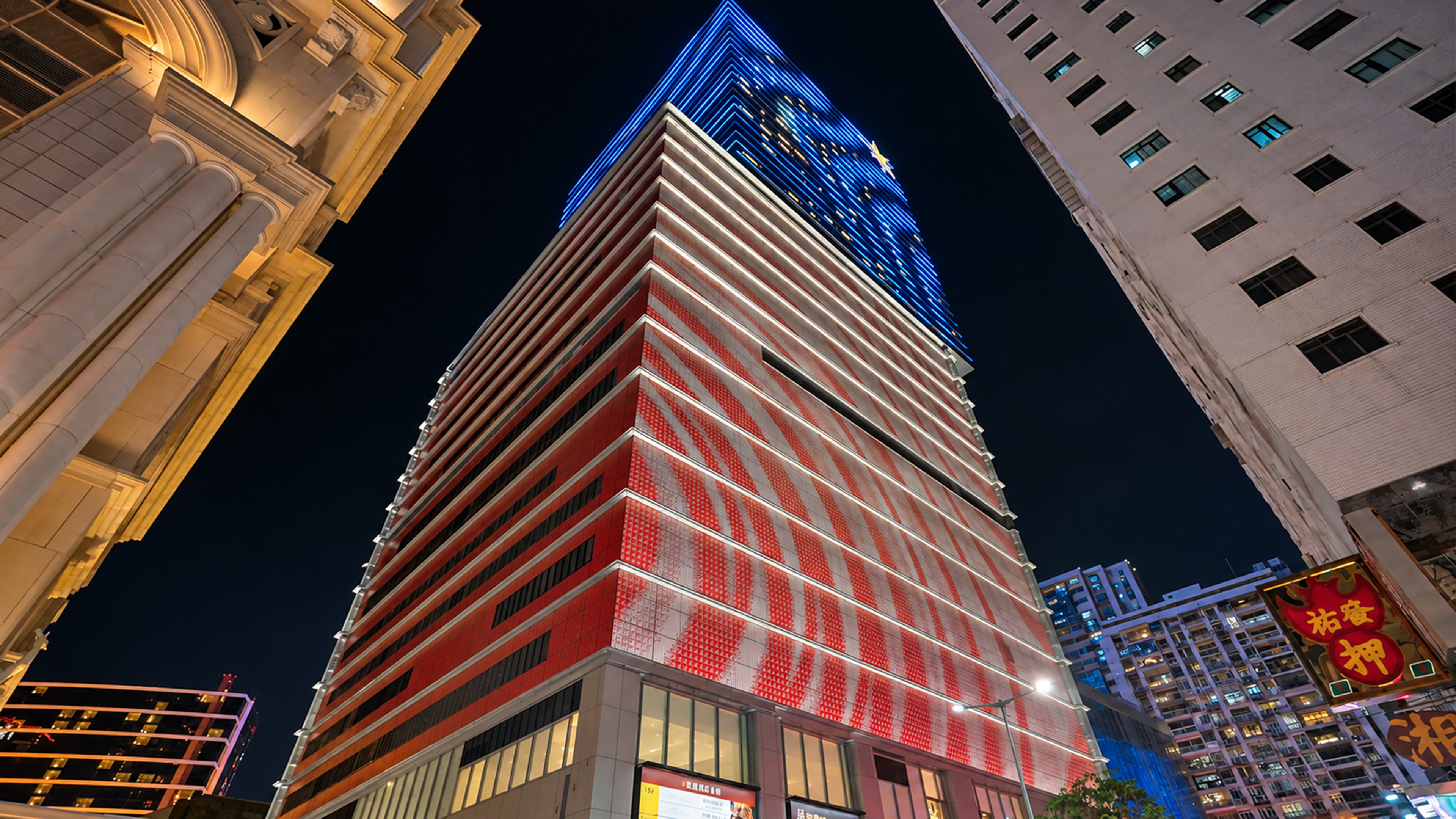 A giant red building in Macau has a glowing blue top