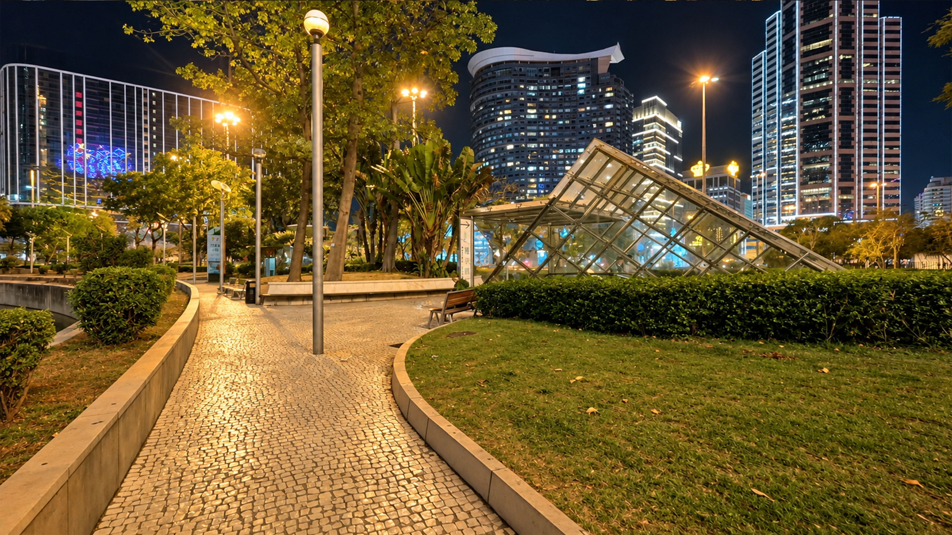 A slanted glass structure sits between Macau's glowing skyscrapers