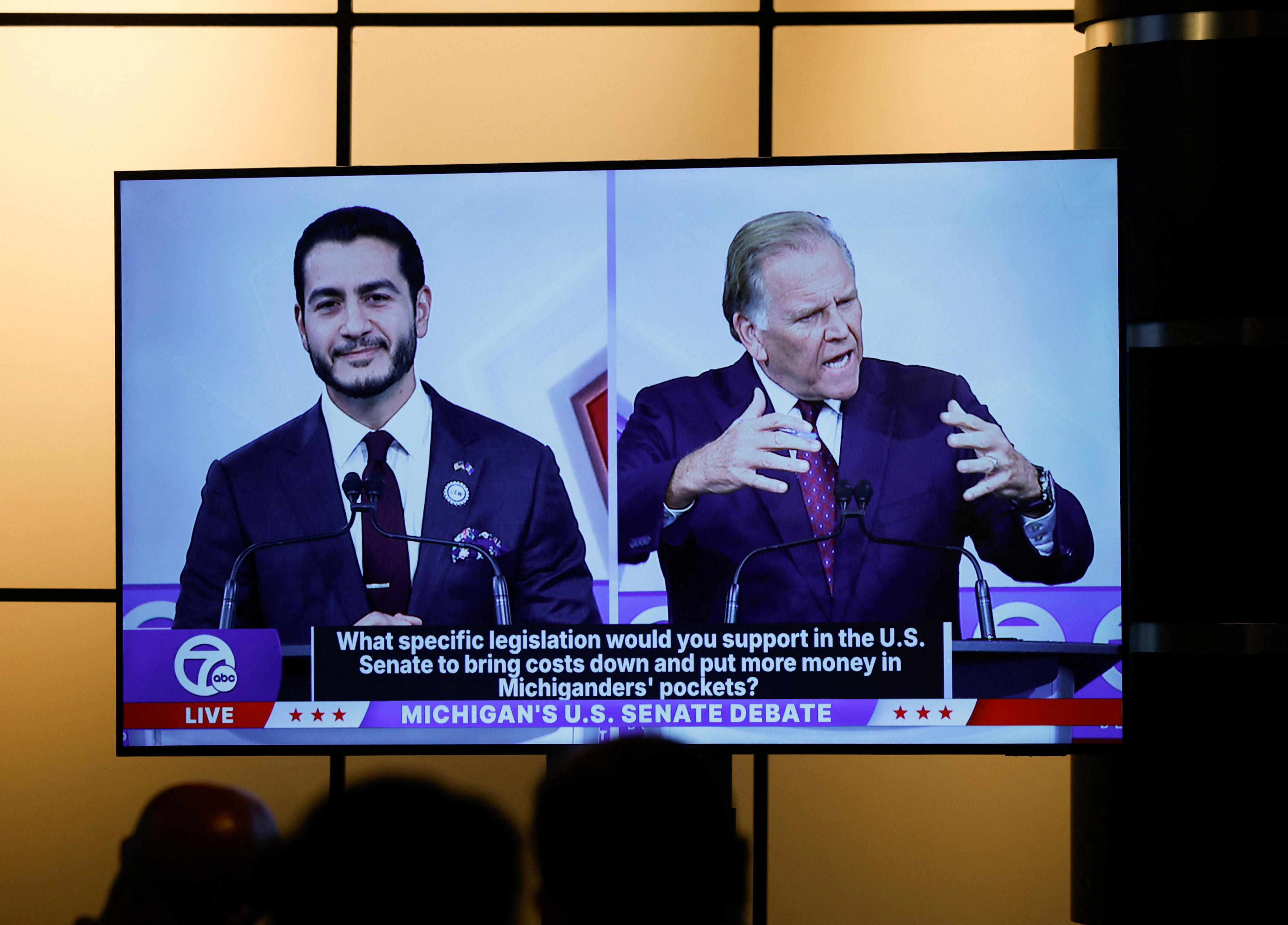 El candidato demócrata al Senado de los Estados Unidos, Abdul El-Sayed, y el candidato republicano al Senado de los Estados Unidos, Mike Rogers, aparecen en una pantalla en la sala de prensa durante su debate para el Senado de los Estados Unidos en Southfield, Michigan, el 21 de octubre de 2026.