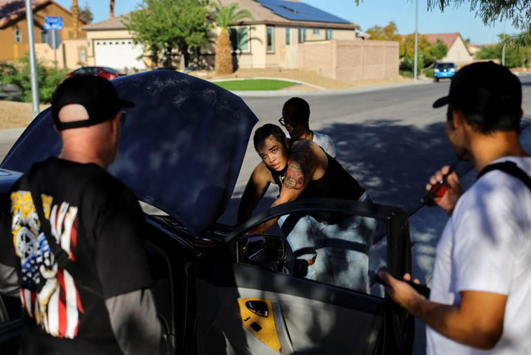 A Teamsters member works on her car while listening to fellow members Larry Goldfinger (L), 63, and Paul Snow (R), 44, speak in support of Nevada gubernatorial candidate Aaron Ford ahead of the midterm elections in Las Vegas, Nevada, US, October 2, 2026. Goldfinger said he worries the rise of AI in Las Vegas will not only cost the city lots of jobs, but also ultimately hurt business by making it less welcoming to tourists accustomed to interacting with well-trained hospitality staff. "We are not against the changes," he said. "We just want to make sure we are involved in how it's changing." REUTERS/Daniel Cole
