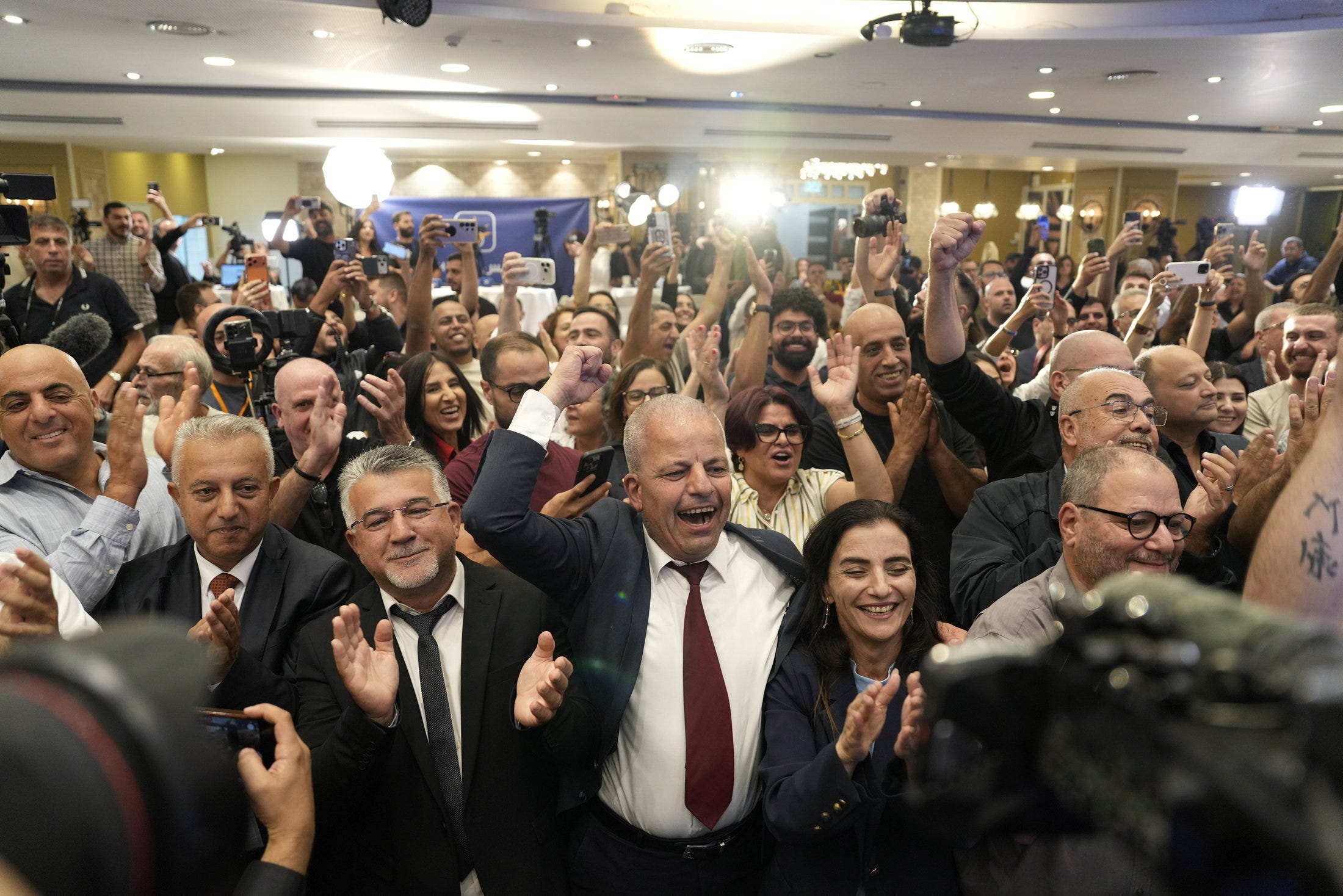 Yousef Jabareen, third from left, celebrates the exit poll results with supporters and members of his Joint List pa... Credit: Daniel Rolider