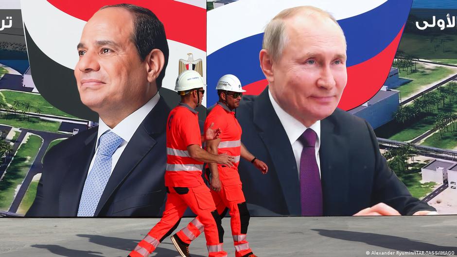 Des ouvriers passent devant des affiches représentant le président égyptien Abdel Fattah al-Sissi et le président russe Vladimir Poutine, sur le chantier de la centrale nucléaire d’El-Dabaa, la première centrale nucléaire d’Égypte, située sur la côte méditerranéenne, à environ 300 kilomètres au nord-ouest du Caire.