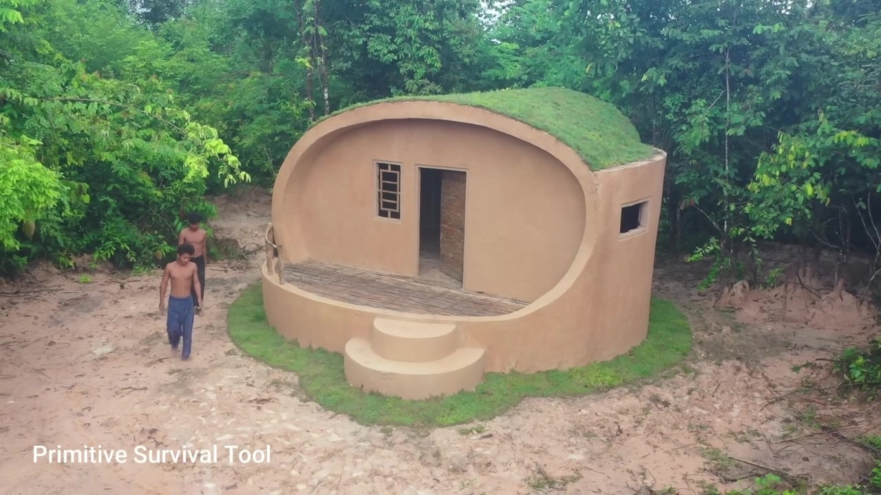Grass-roofed underground house with curved entrance steps