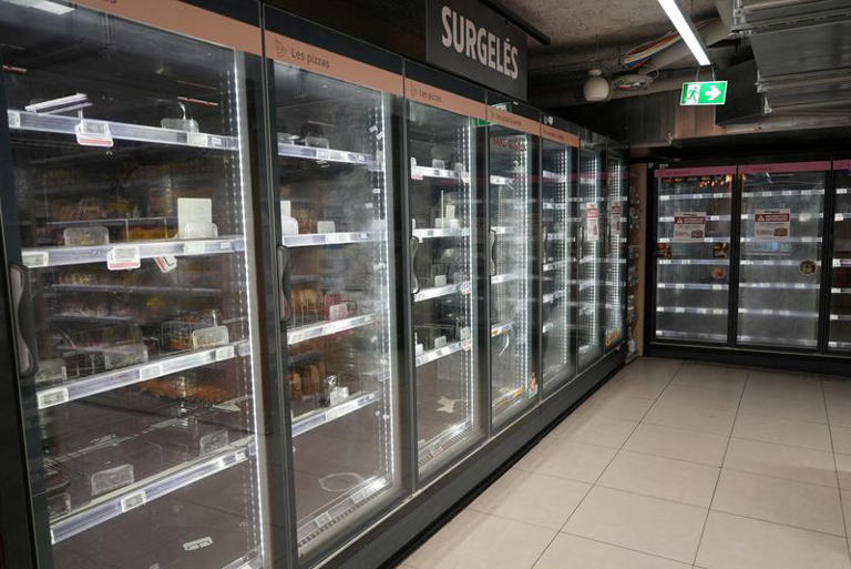View of empty refrigerators at the frozen food aisle inside an Intermarche supermarket in Paris the day after a cyberattack targeted refrigeration systems at French supermarket chains, causing food losses and fires at several stores, France, October 13, 2026. REUTERS/Lucien Libert/File Photo