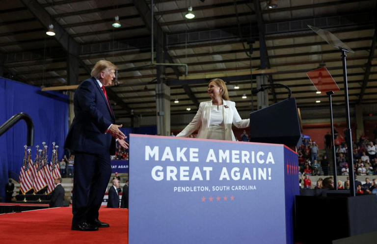 US President Donald Trump shares the stage with Republican US Senate candidate Darline Graham during a rally ahead of the midterm elections, at T. Ed Garrison Arena at Clemson University in Pendleton, South Carolina, US, October 21, 2026. REUTERS/Umit Bektas