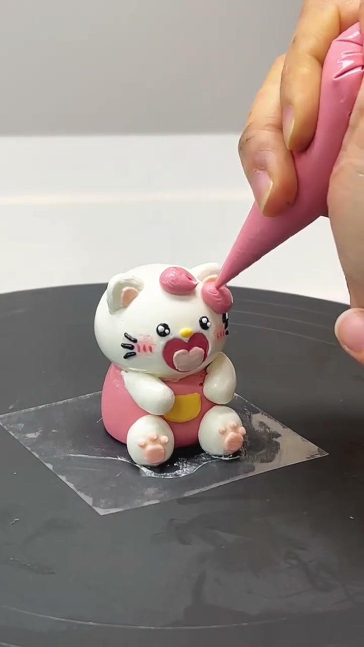 Pink kitten cake topper with a heart bib