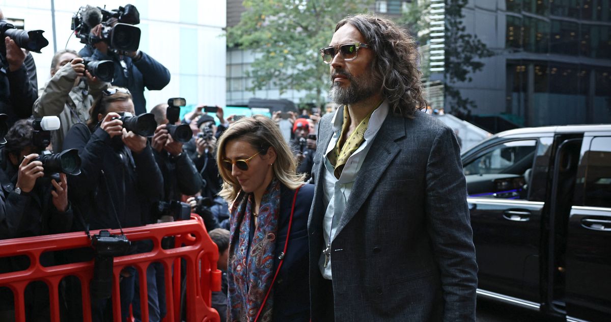 Russell Brand's wife tries to defend him in court