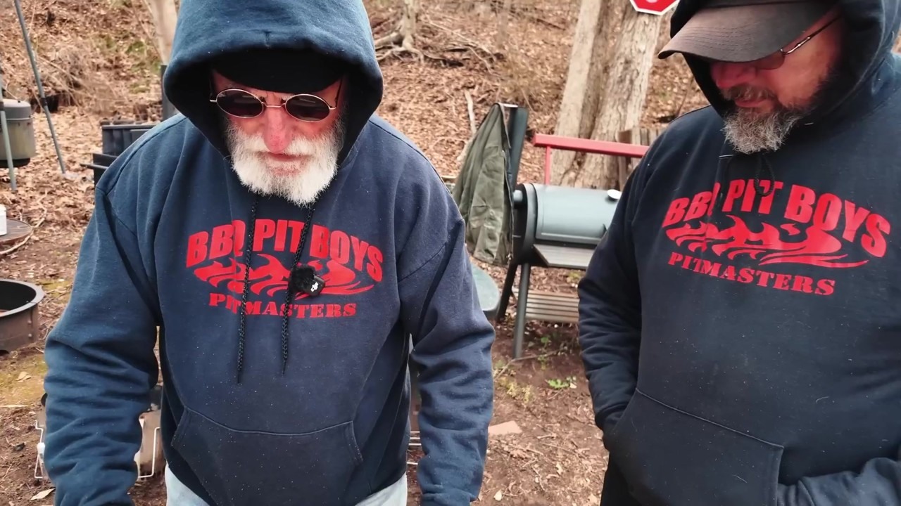 Pitmasters roll bacon into a brisket for the rotisserie