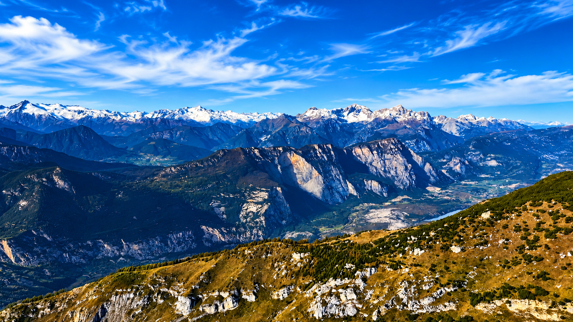 Panoramic views of snow-capped alpine mountains and deep green valleys