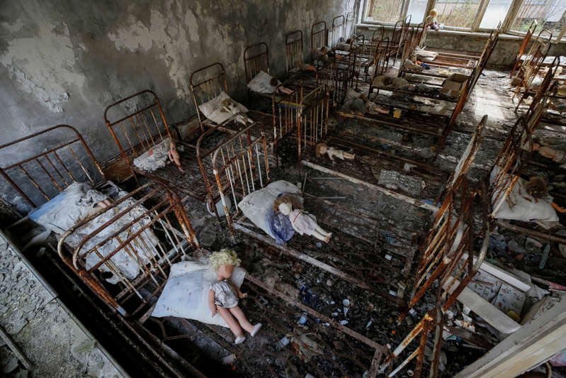 一个肮脏的旧房间：由游客放置的玩偶，躺在乌克兰切尔诺贝利核电站附近废弃城市普里皮亚季的一所幼儿园的床上。 REUTERS / Gleb Garanich