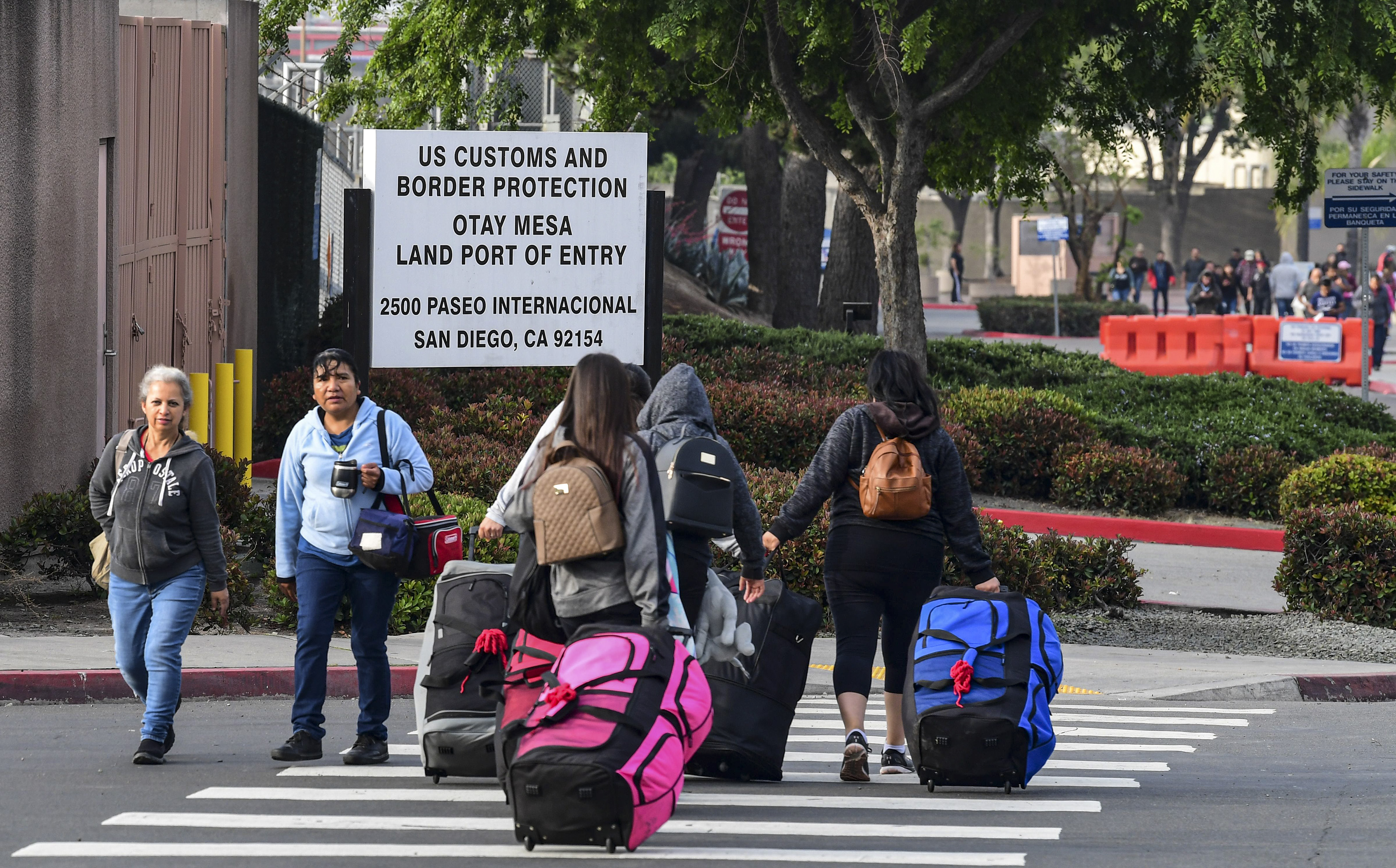 Slide 3 of 75: People make their way to and from the US-Mexico border at the Otay Mesa Port of Entry in San Diego, California on June 8, 2019. - US President Donald Trump touted on Saturday his last-minute deal averting tariffs on Mexico, a plan economists warned would have been disastrous for both countries, saying the agreement will be a big success if America's southern neighbor cracks down on illegal immigration as promised.