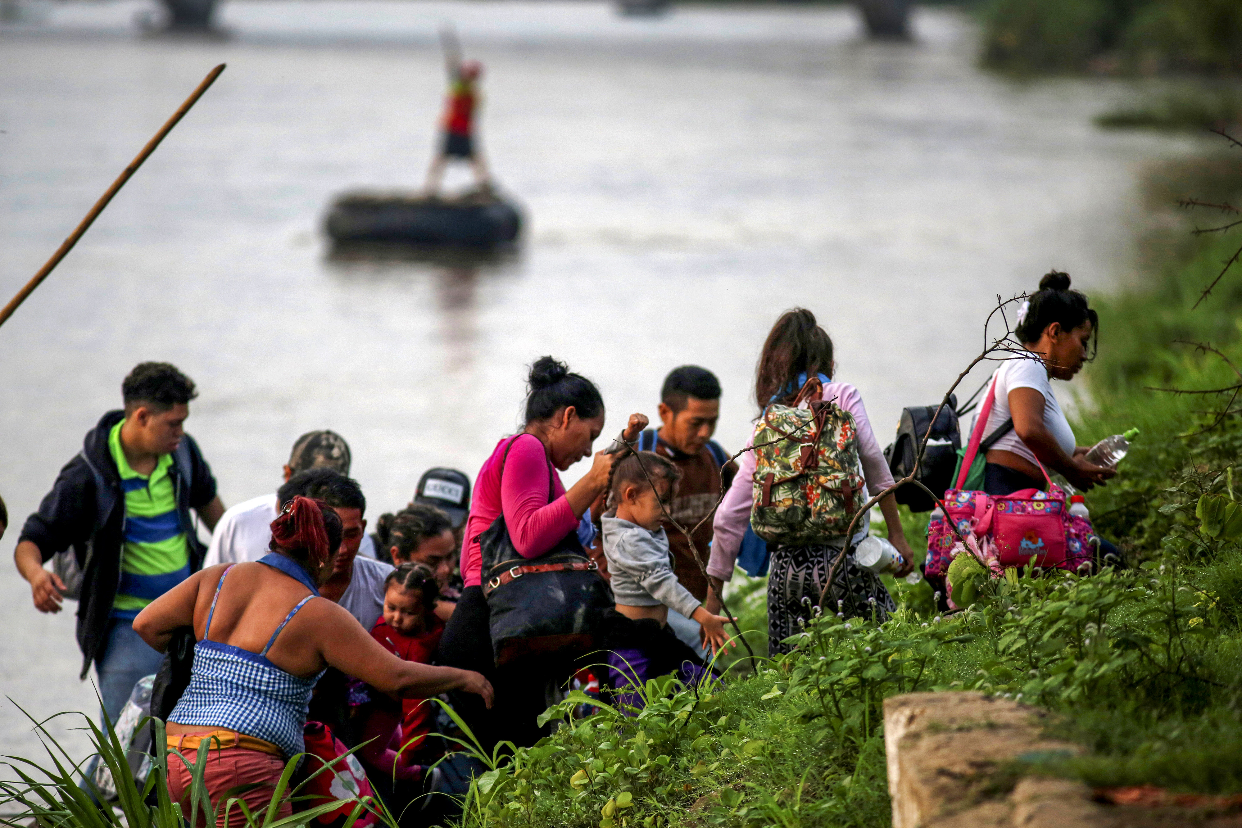 Slide 4 of 75: Central American migrants get off a raft after crossing the Suchiate river from Tecun Uman, in Guatemala, to Ciudad Hidalgo, as seen from Ciudad Hidalgo, Mexico, June 8, 2019.