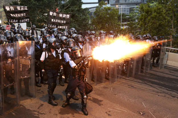 Slide 2 of 39: Police officers fire a tear gas during a demonstration against a proposed extradition bill in Hong Kong, China June 12.
