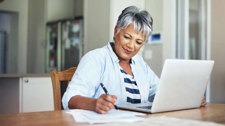 a person sitting at a table using a laptop