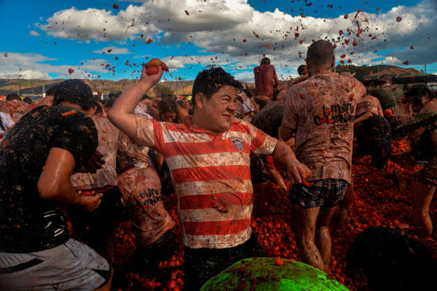 Slide 4 of 31: People participate in the tenth annual tomato fight festival, known as 
