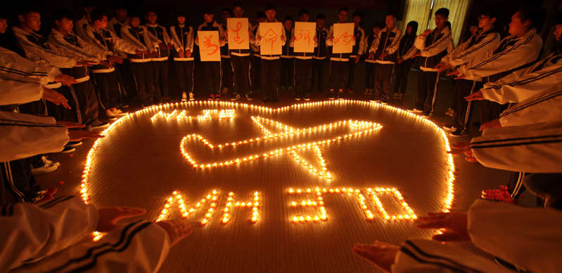 2014年3月10日，来自中国东部城市诸暨国际学校的学生通过点燃蜡烛在马来西亚航空公司MH370航班上为乘客祈祷。 马来西亚航空公司MH370航班从吉隆坡飞往北京，载有239人，据报道，当船员在马来西亚和越南胡志明市之间的水域上空飞行时未能按计划办理登机手续。 （VCG / VCG通过Getty Images拍摄）