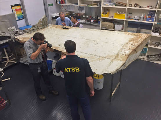 在2016年9月16日星期五由澳大利亚运输安全局（ATSB）发布的这张照片中，工作人员在7月份在澳大利亚堪培拉的实验室检查了一块飞机残骸。 6月2016年，坦桑尼亚海岸Pemba岛上的居民发现了这个襟翼，官员此前表示很可能来自MH370航班。 该机构在一份声明中表示，澳大利亚运输安全局专家正在寻找这架飞机，后来证实该部件确实来自失踪的波音777飞机。 （照片/ ATSB通过AP）