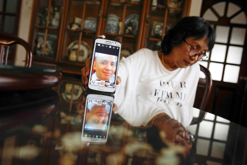 Sakinab Shah是马来西亚370航班的高级飞行员Zaharie Ahmad Shah的妹妹，她在马来西亚吉隆坡的家中接受采访时用手机拍摄了她兄弟的最新照片。 澳大利亚官员于2016年7月28日星期四证实，从马来西亚航空公司370航班机长拥有的家用飞行模拟器中恢复的数据显示，有人曾使用该设备在印度洋南部划出一条航线，相信失踪的喷气机坠毁了。 （美联社照片/约书亚保罗，档案）